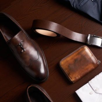 Mans fashion and accessories, set of brown leather shoes, purse, belt, white shirt and dark trousers on wooden background